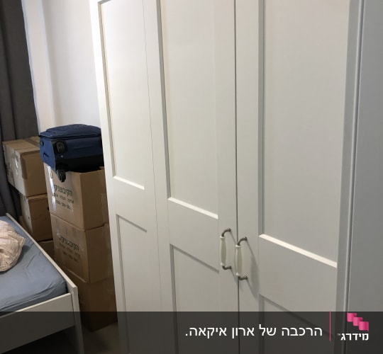 ארון לבן עם ידיות מתכת בחדר שינה